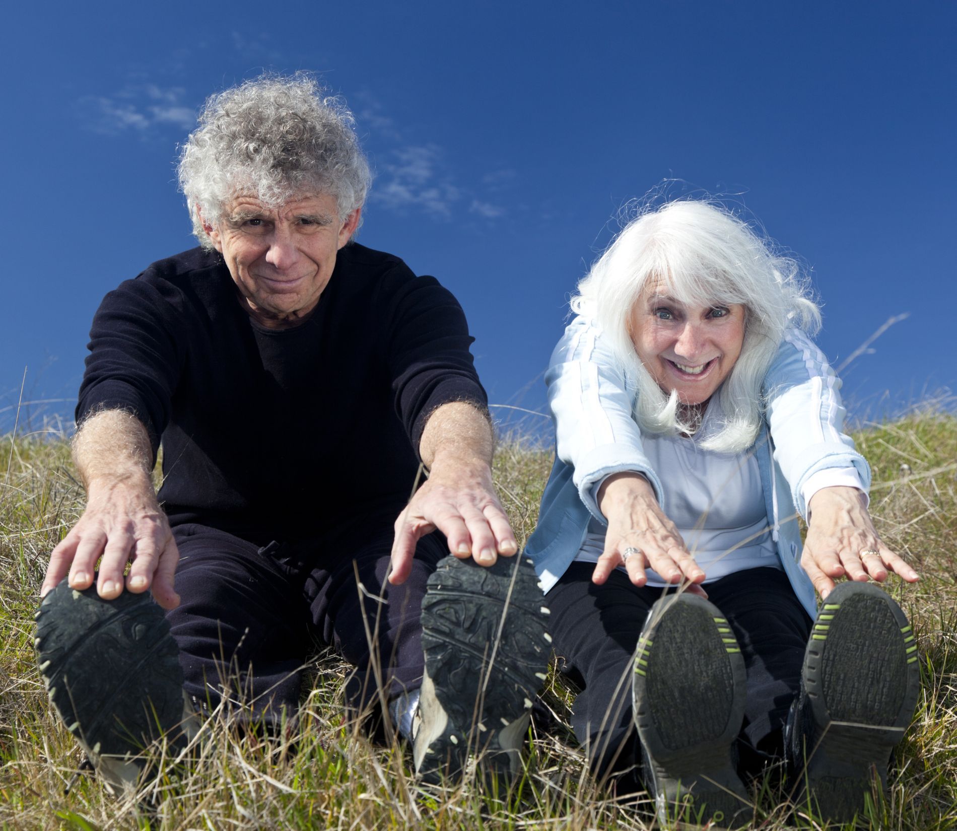 Rochelle and Errol and on ground stretching toward toes.