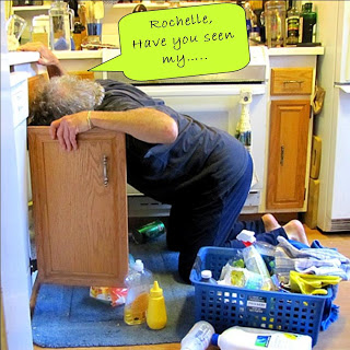 Errol on knees looking for something under sink