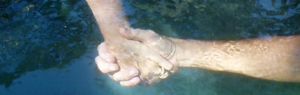 awakening humanity through human connection like the two human hands joined underwater