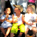 three littke kids eating ice cream cones with blissful look on their faced looking up eyes closed